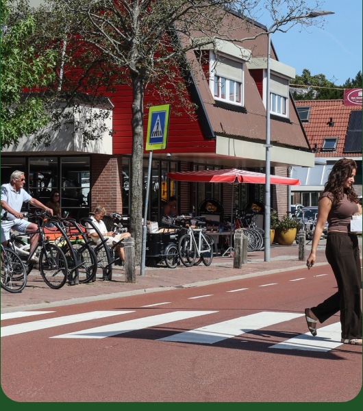 Dorpsstraat met café en fietsers in Blokker